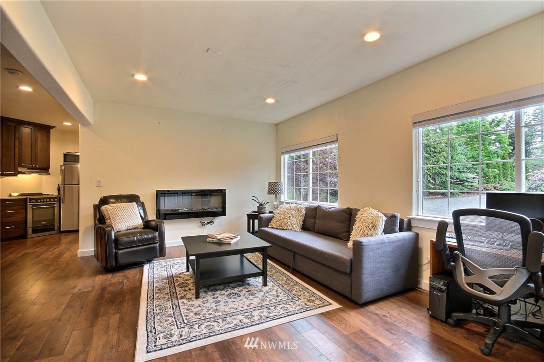 4706 224th Street Southeast Bothell, WA 98021 - Photo 29 of 38 a living room with furniture floor to ceiling window hardwood floor and a rug