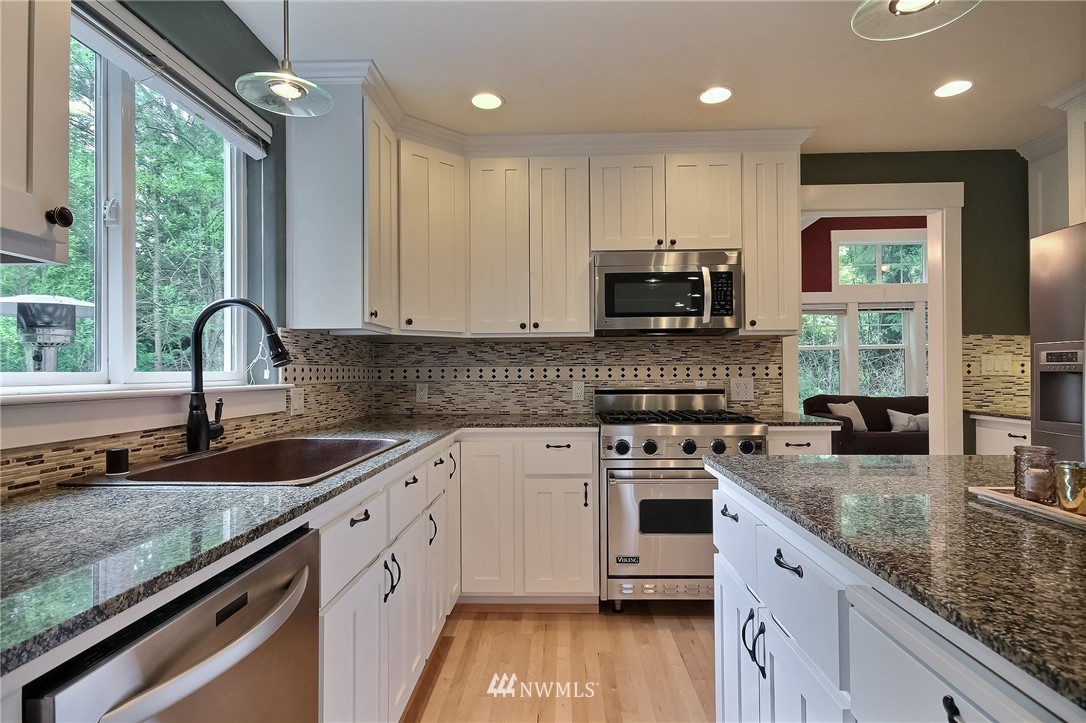 4706 224th Street Southeast Bothell, WA 98021 - Photo 10 of 38 a kitchen with granite countertop a sink a counter space appliances and cabinets