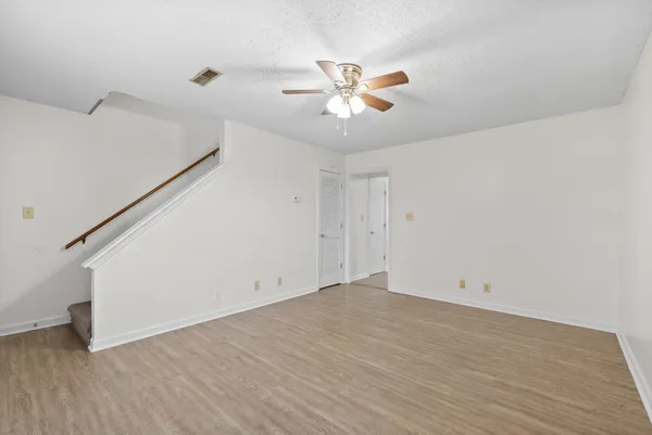 a view of a big room with wooden floor and windows in a room