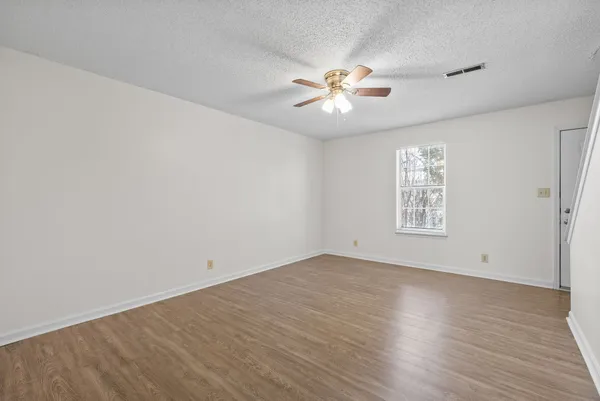 a view of an empty room with wooden floor
