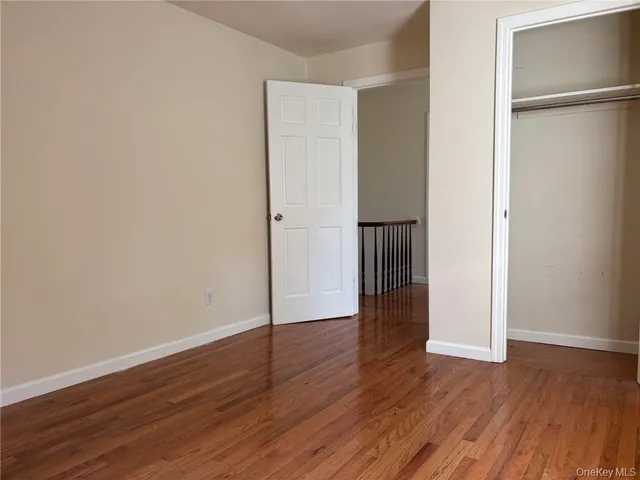 an empty room with wooden floor and closet