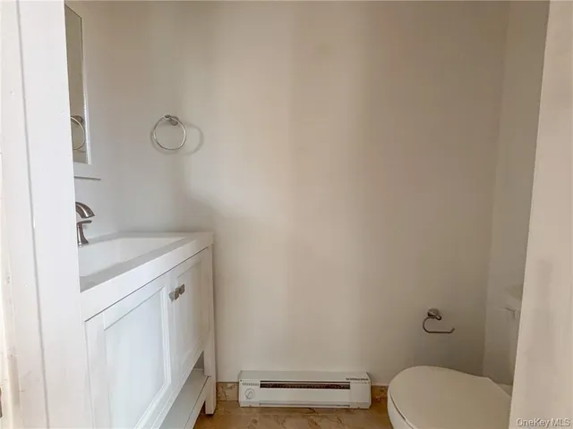 a bathroom with a granite countertop toilet and a sink