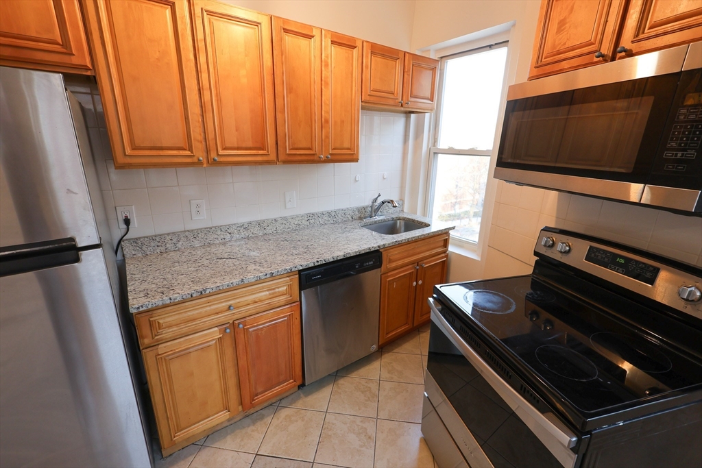 a kitchen with stainless steel appliances a stove microwave and refrigerator