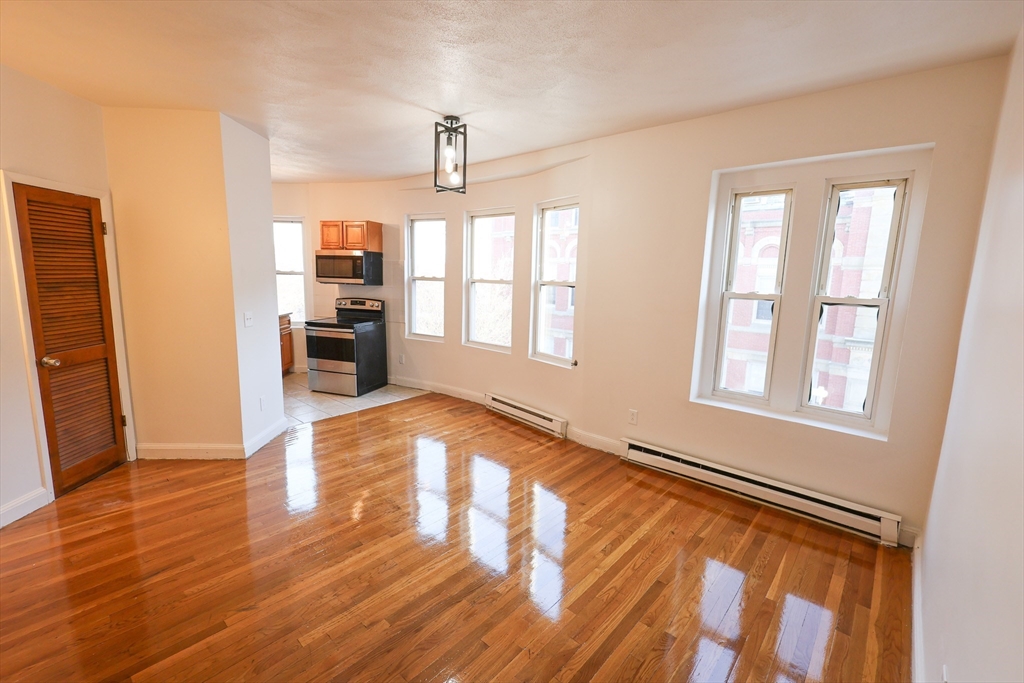 1 Kenilworth Street, Unit 3 Boston, MA 02119 - Photo 5 of 10 a view of an empty room with window and wooden floor