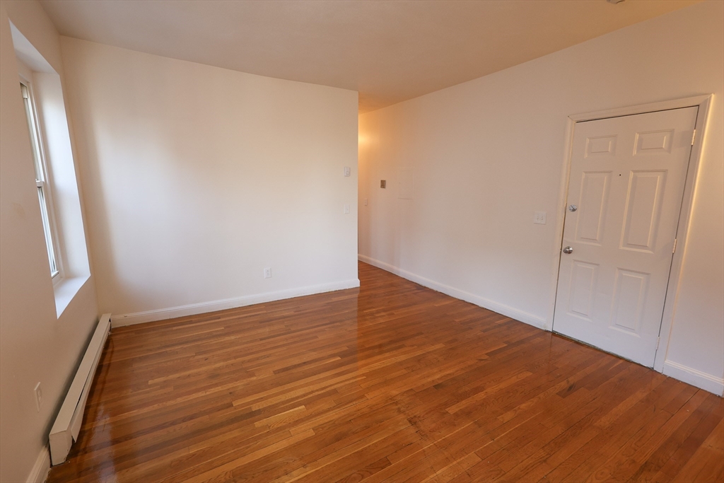 1 Kenilworth Street, Unit 3 Boston, MA 02119 - Photo 6 of 10 a view of an empty room with wooden floor and a window