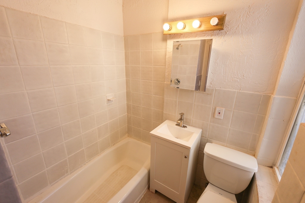 1 Kenilworth Street, Unit 3 Boston, MA 02119 - Photo 9 of 10 a bathroom with a sink a toilet and shower