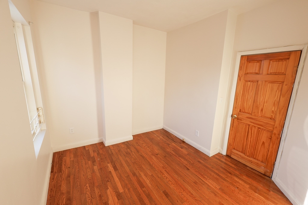 1 Kenilworth Street, Unit 3 Boston, MA 02119 - Photo 10 of 10 an empty room with wooden floor and sliding door