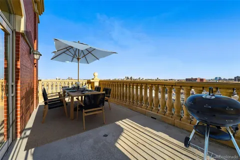 a view of a roof deck with chair and wooden floor