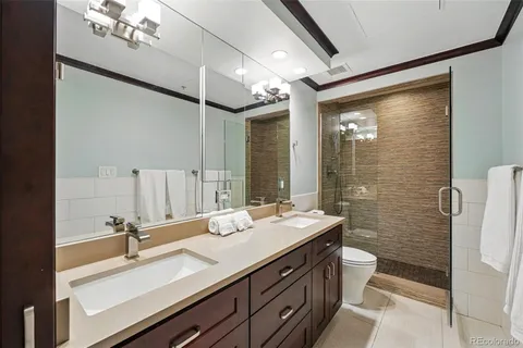 a bathroom with a double vanity sink a toilet and mirror