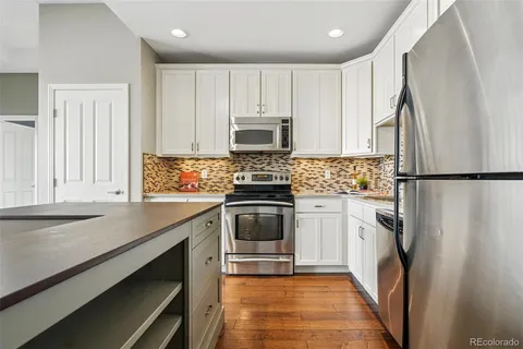 a kitchen with white cabinets and stainless steel appliances