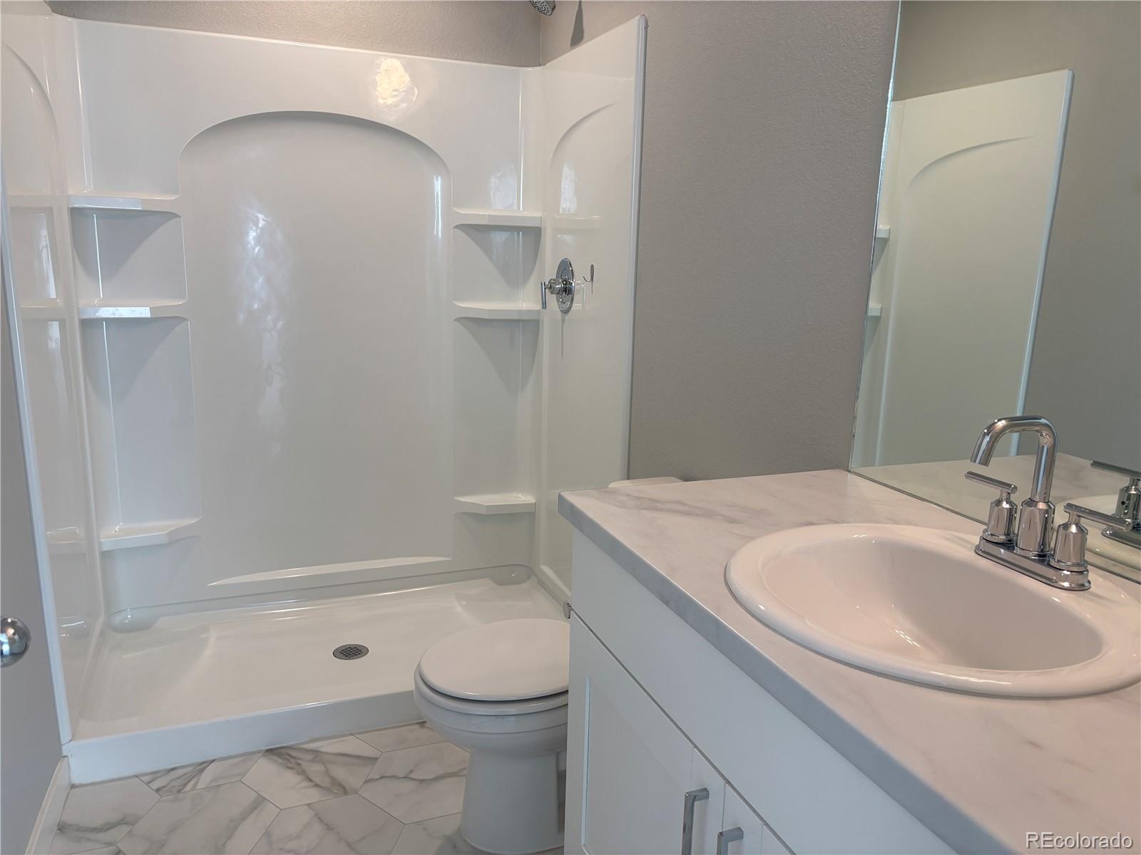 260 Pawnee Road, Unit C1 Ault, CO 80610 - Photo 12 of 14 a bathroom with a sink a toilet and shower