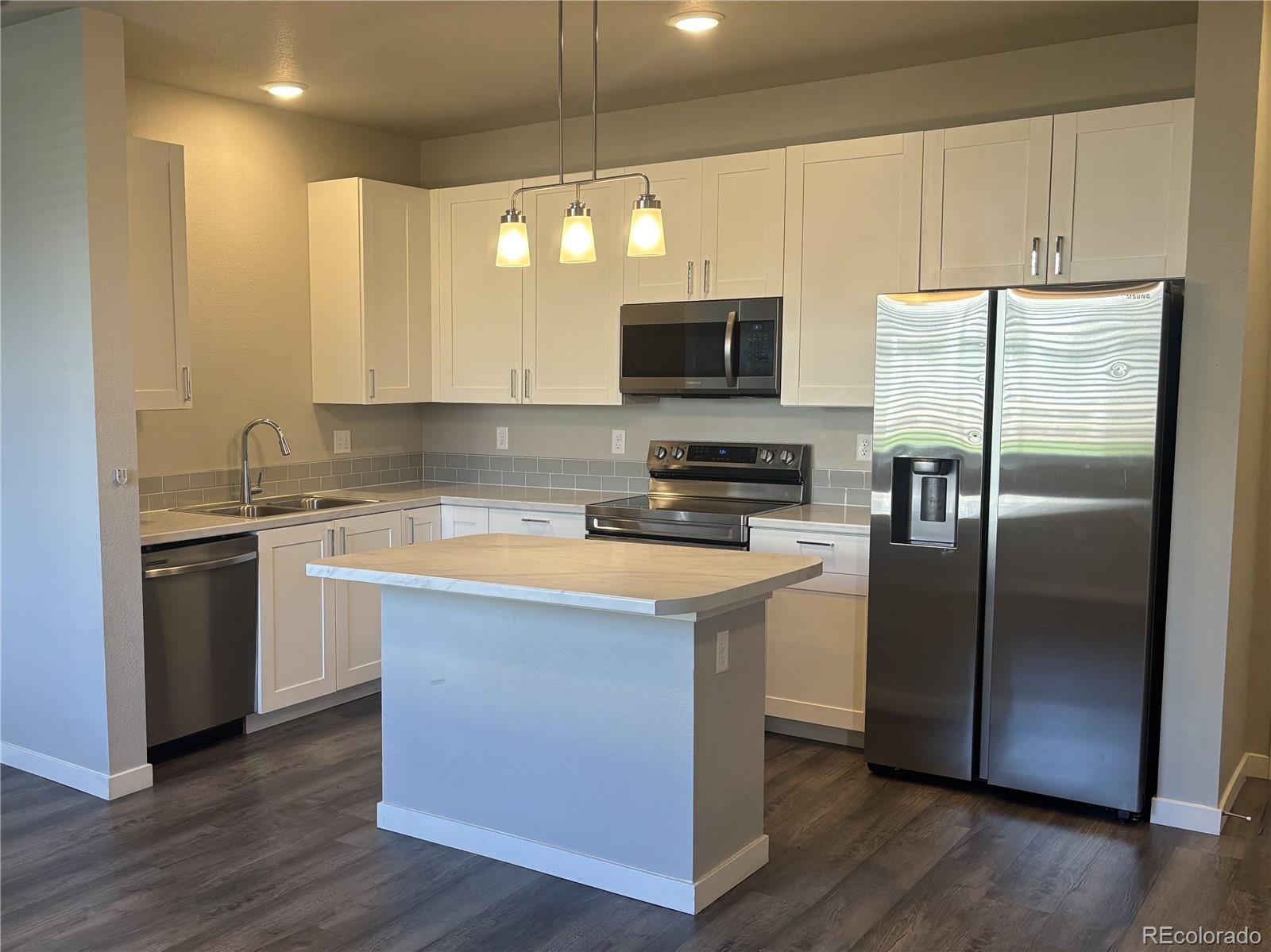 260 Pawnee Road, Unit C1 Ault, CO 80610 - Photo 3 of 14 a kitchen with a refrigerator a microwave a sink and cabinets