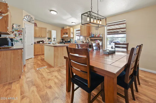 a kitchen with stainless steel appliances granite countertop a table chairs and couches