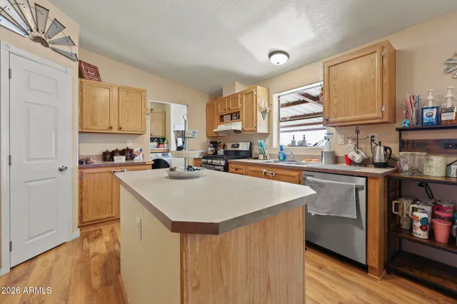 a kitchen with stainless steel appliances granite countertop a sink a stove and a refrigerator