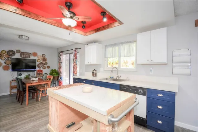 a kitchen with a stove a sink dishwasher and a dining table with wooden floor