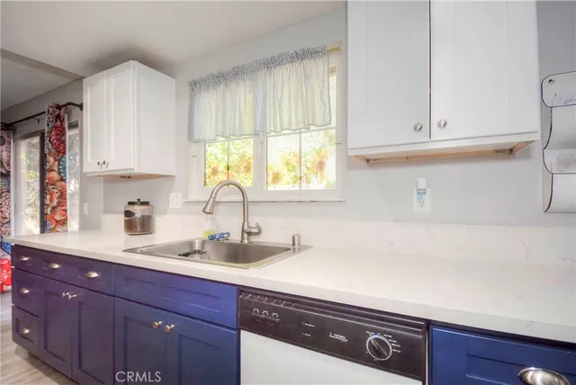 a kitchen with granite countertop white cabinets and white appliances