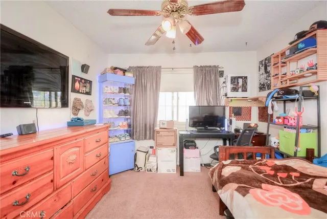 a bedroom with furniture a flat screen tv and a fireplace