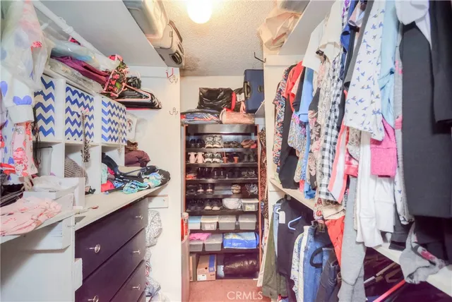 a view of walk in closet with clothes
