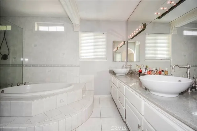 a bathroom with a white tub a sink and a window