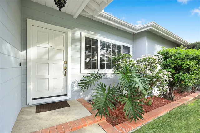 a living room with couches a coffee table and a large window with wooden floor