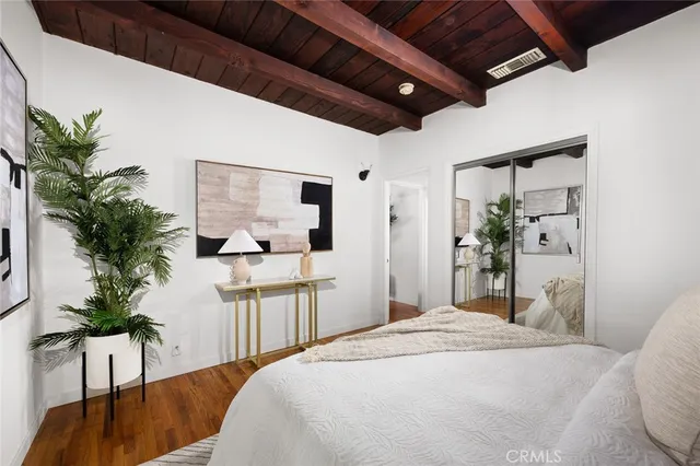 a spacious bedroom with a bed a couch and potted plant with the outer view
