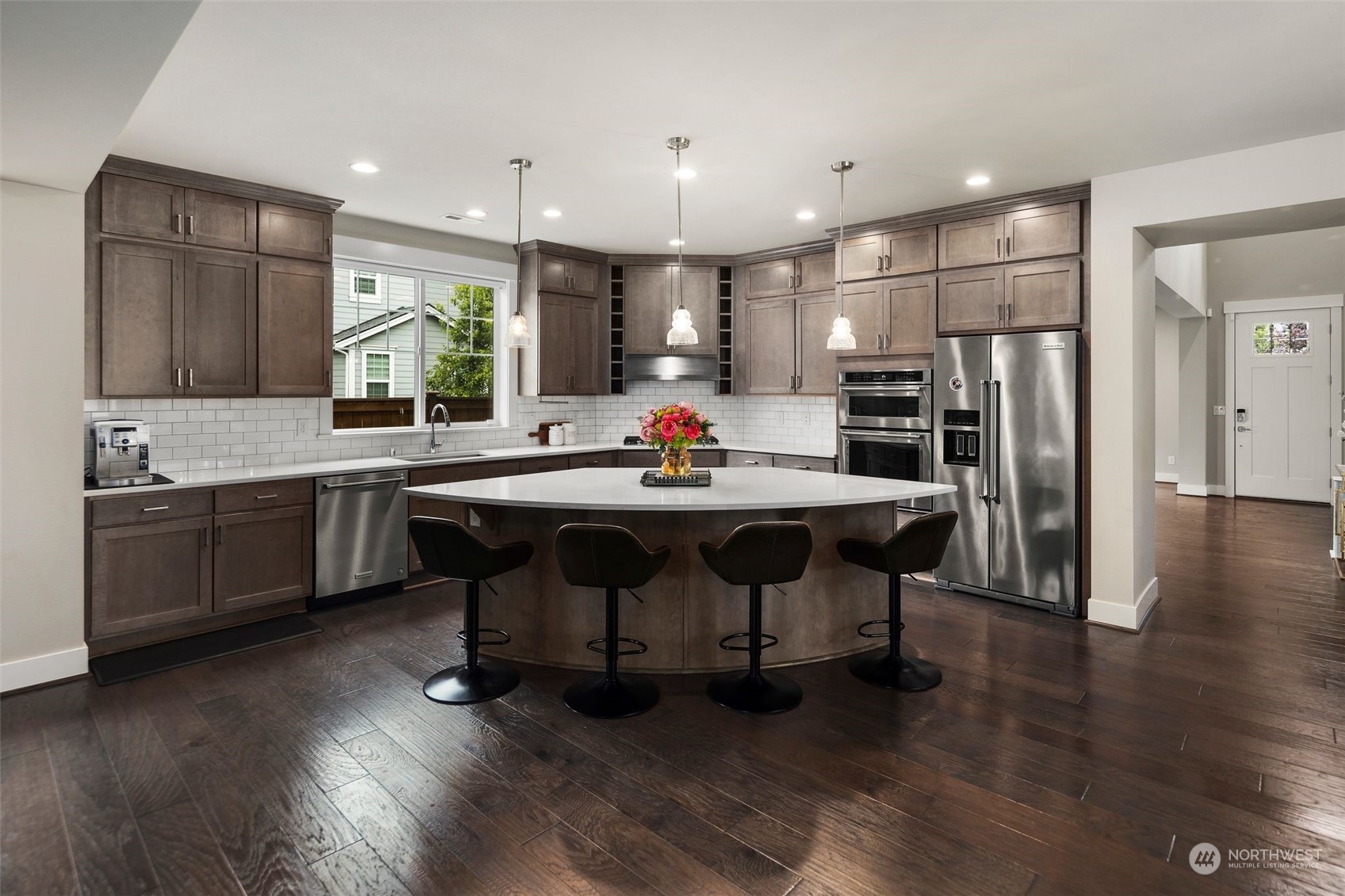 16025 Southeast 144th Street Renton, WA 98059 - Photo 20 of 40 a kitchen with stainless steel appliances a dining table chairs refrigerator and sink