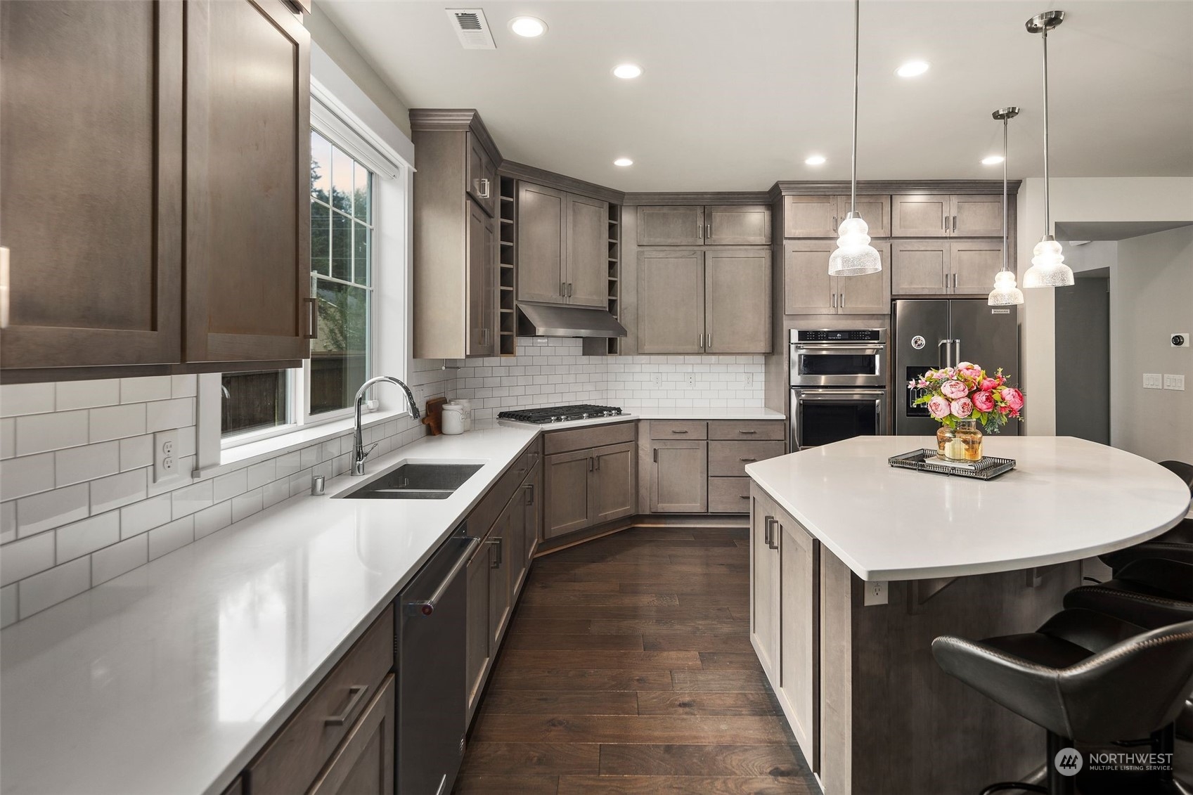 16025 Southeast 144th Street Renton, WA 98059 - Photo 21 of 40 a kitchen with stainless steel appliances kitchen island granite countertop a sink a stove a refrigerator and island with wooden floor
