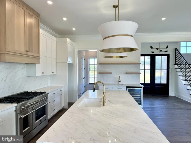 a kitchen with stainless steel appliances granite countertop a stove and a wooden floors