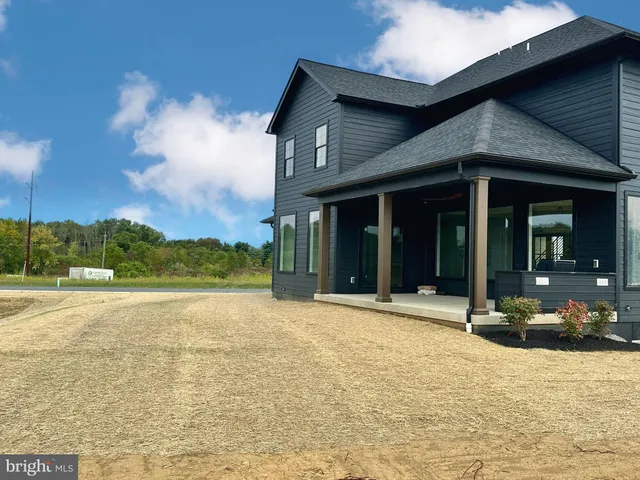 a view of a house with floor to ceiling windows and a yard