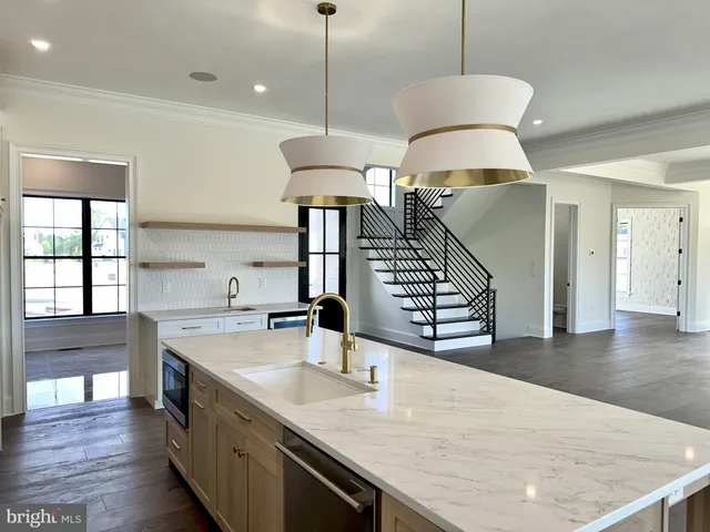 a kitchen with stainless steel appliances granite countertop a sink a oven and a dining table with wooden floor