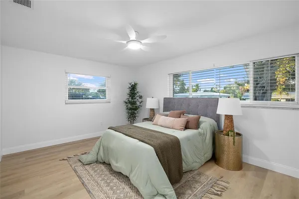 a bedroom with a bed and wooden floor