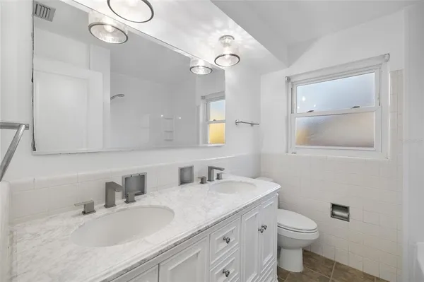 a bathroom with a granite countertop sink mirror and toilet