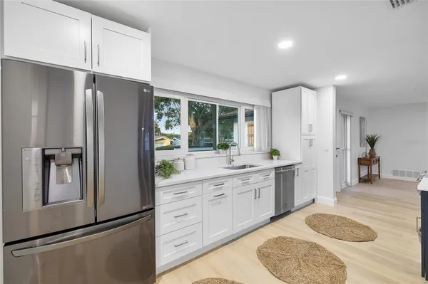 a kitchen with stainless steel appliances granite countertop a refrigerator and a sink