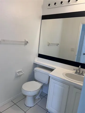 a bathroom with a toilet a sink and mirror