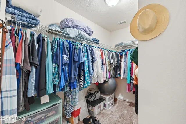 a view of walk in closet with clothes