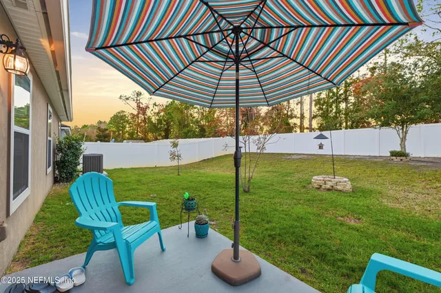a backyard of a house with table and chairs