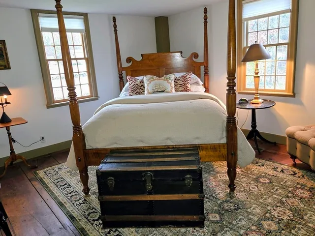 a bed sitting in a bedroom next to a window