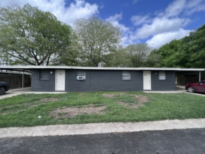 Ranch-style home featuring an attached carport and a front lawn