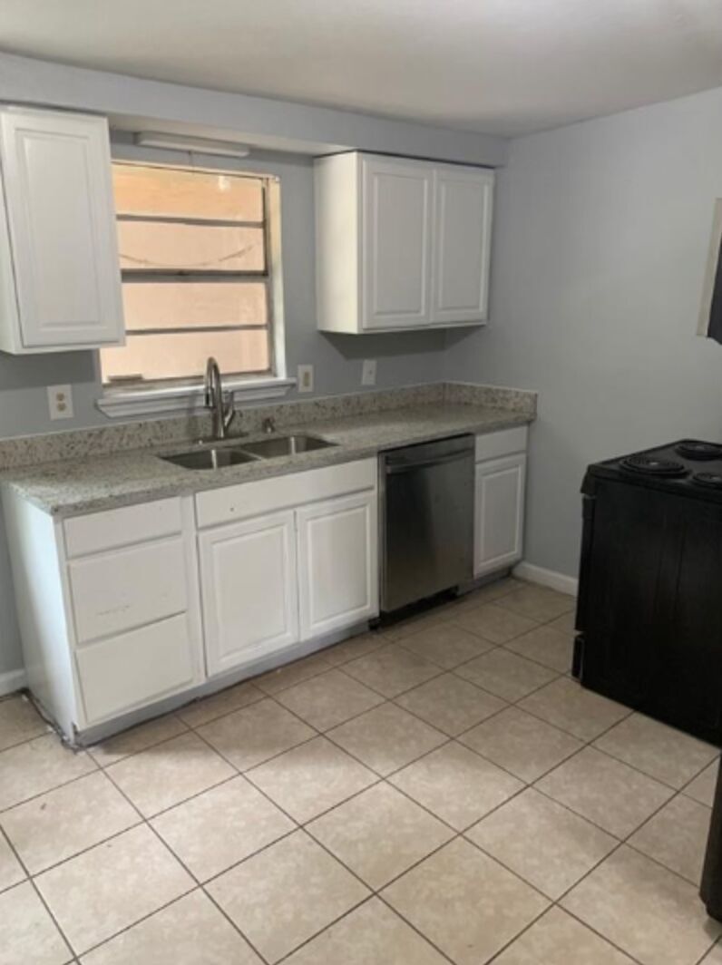 1015 Hackberry Street, Unit B San Marcos, TX 78666 - Photo 2 of 9 Kitchen featuring white cabinets, electric range, dishwasher, and light tile patterned floors