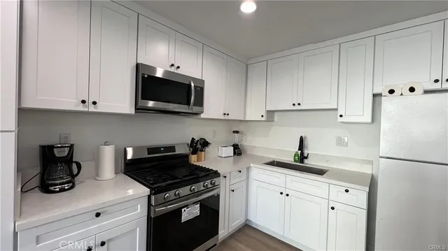 a kitchen with white cabinets and stainless steel appliances