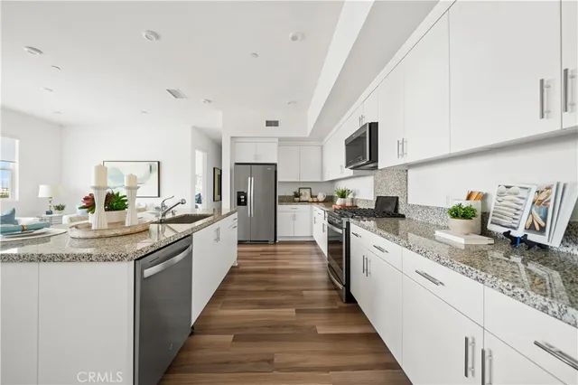 a kitchen with granite countertop white cabinets and white appliances