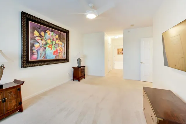 a view of an empty room with furniture and mirror