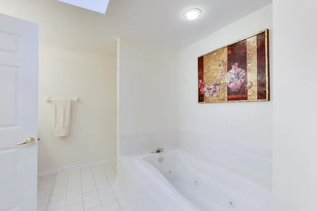 a white bath tub sitting next to a white wall