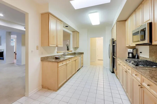 a kitchen with stainless steel appliances granite countertop a stove a sink and a refrigerator