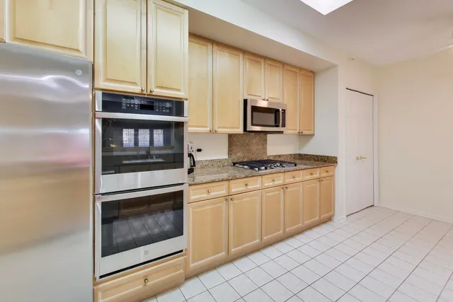 a kitchen with stainless steel appliances granite countertop a stove microwave and sink