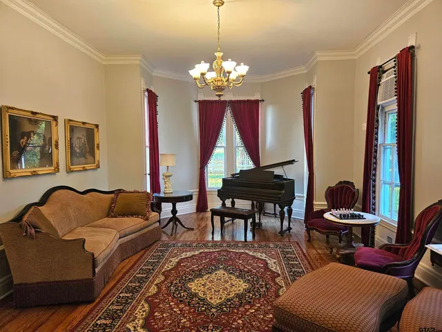 a living room with furniture a dining table and a chandelier