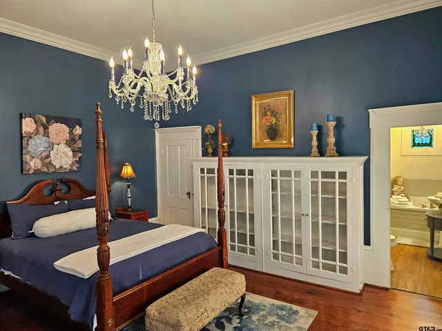 a living room with furniture a chandelier and a wooden floor