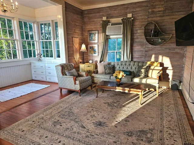 a living room with patio furniture and a wooden floor