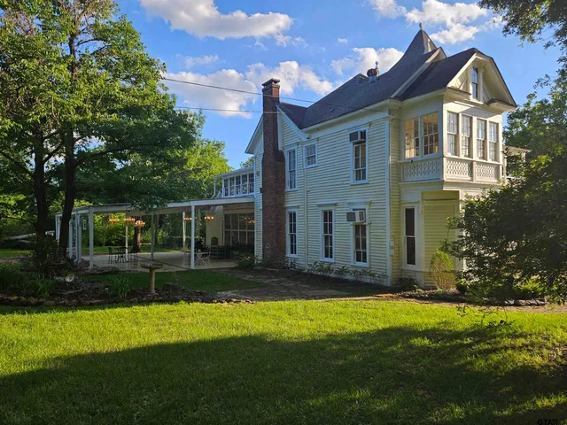 a view of a big house with a big yard and potted plants