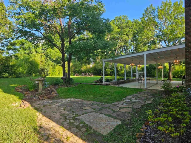 a view of a house with backyard and sitting area
